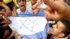 Egyptians protesting Israeli air strikes in Gaza, hold a representation of the Israeli flag in Cairo, Egypt, Nov. 16, 2012. 