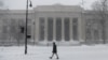 Seorang pejalan kaki melewati salju di luar MIT School of Architecture and Planning selama badai Nor'easter yang kuat di Cambridge, Massachusetts, AS, 29 Januari 2022. (Foto: REUTERS/Nicholas Pfosi)