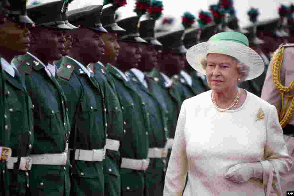 Britain's Queen Elizabeth II reviews the honor guard upon her arrival at Nnamdi Azikiwe International Airport in Abuja, Nigeria, 03 December 2003.
