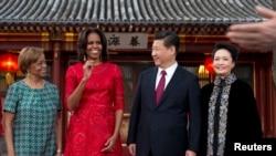 U.S. first lady Michelle Obama, her mother Marian Robinson (L), share a light moment with Chinese President Xi Jinping, and his wife Peng Liyuan (R) after a photograph session at the Diaoyutai State guest house in Beijing, March 21, 2014.