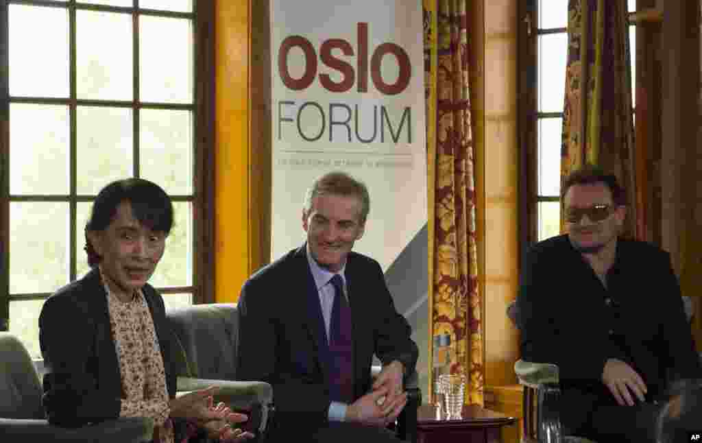 From left, Aung San Suu Kyi, Norway's Foreign Minister Jonas Gahr Stoere and Irish singer and activist Bono address the media after attending a conference of the Oslo Forum, Norway, June 18, 2012.