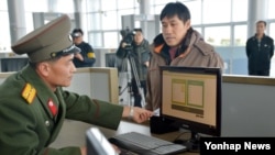 지난 1월 개성공단 전자출입체계(RFID) 시스템이 본격적인 시범 가동에 들어간 가운데 북측 출입사무소의 직원이 전자시스템을 이용해 개성공단 출입 심사를 하고 있다.