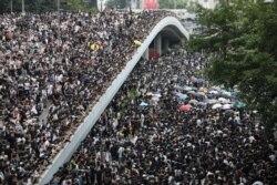 FILE - Protesters march along a road demonstrating against a proposed extradition bill in Hong Kong, China, June 12, 2019.