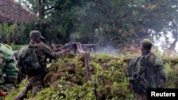 A Congolese soldier shoots in the direction of M23 rebels from their position near the Rumangabo military base in Runyoni, 58 km (36 miles) north of Goma, Oct.31, 2013.
