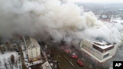 In this Russian Emergency Situations Ministry photo, on Sunday, March 25, 2018, smoke rises above a multi-story shopping center in the Siberian city of Kemerovo, about 3,000 kilometers (1,900 miles) east of Moscow, Russia. 