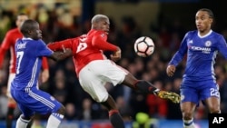 Paul Pogba, de Manchester United, contrôle le ballon sous l’œil vigilant de N'Golo Kante de Chelsea, à gauche, et de Willian, à droite, pendant le match de quart de finale de la coupe de la ligue anglaise entre Chelsea et Manchester United, le 13 mars 2017