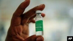 FILE - In this March 24, 2021 file photo, a nurse holds a vial of the AstraZeneca COVID-19 vaccine, manufactured by the Serum Institute of India and provided through the global COVAX initiative, prior to vaccination in Machakos, Kenya.