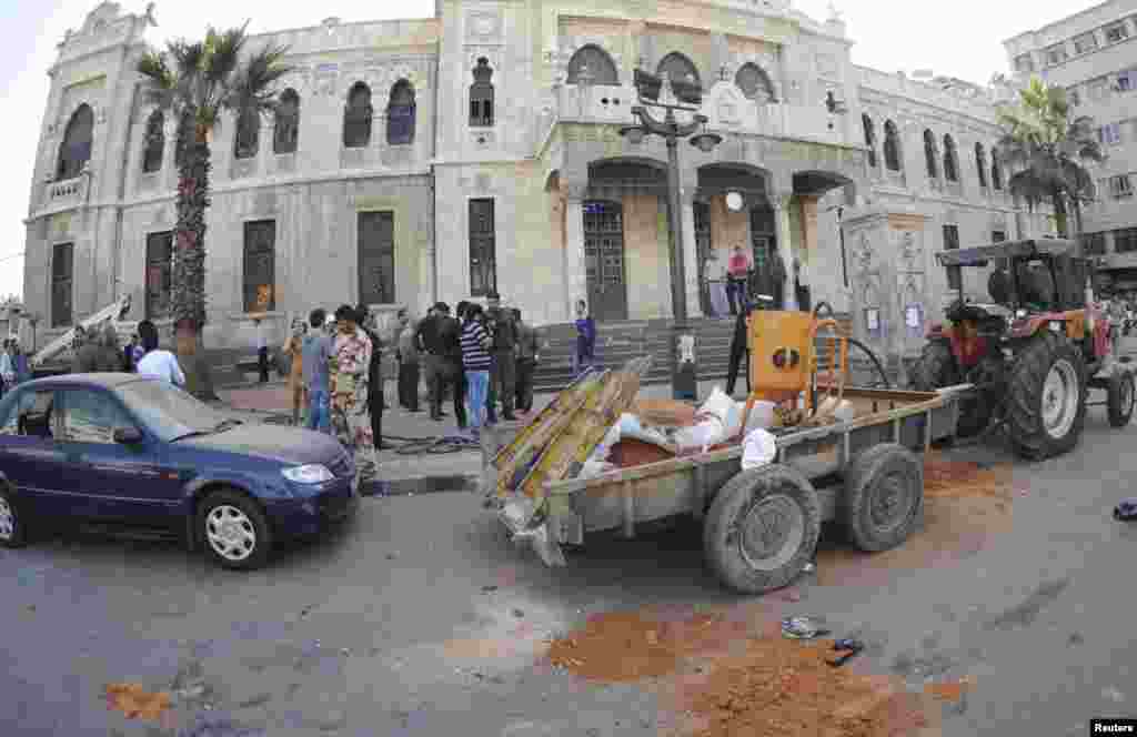 People gather around the scene of a bomb explosion in front of of al-Hejaz train station in central Damascus, Nov. 6, 2013, in this handout picture released by SANA.