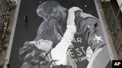 People walk beside a giant mural of former NBA basketball player Kobe Bryant and daughter Gianna at a basketball court in Taguig, south of Manila, Philippines on Jan. 28, 2020.