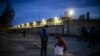 Migrant workers stand by the barbed wire fence of the IK-3 penal colony where jailed Kremlin critic Aleksey Navalny was reportedly transferred in the city of Vladimir, April 19, 2021.