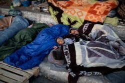Refugees and migrants from the destroyed Moria camp sleep on the side of a road, on the island of Lesbos, Greece, Sept. 13, 2020.