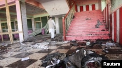 Seorang pria Afghanistan memeriksa lokasi ledakan bom yang terjadi saat pesta pernikahan di privinsi Samangan, Sabtu (14/7).