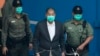 FILE - Jimmy Lai is escorted by Correctional Services officers to get on a prison van before appearing in a court in Hong Kong, Dec. 12, 2020. Hong Kong journalists said Lai's prosecution was "highly damaging" to press freedom.
