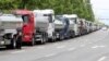 Anggota serikat Solidaritas Pengemudi Truk Kargo berdiri di samping truk saat mogok kerja di Yeosu, Korea Selatan, 9 Juni 2022. (Foto: via Reuters)