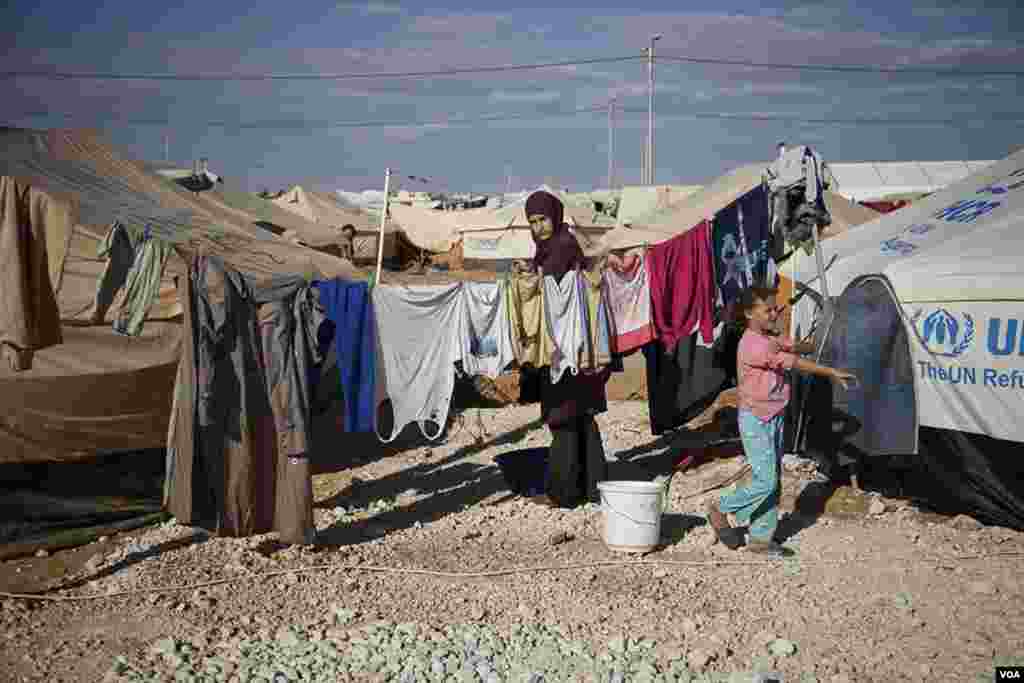 A woman hangs clothes to dry at the Za'tari refugee camp. (Y. Weeks/VOA)