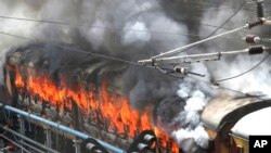 Flames rise from a train set on fire by protesters at Secundrabad railroad station in Hyderabad, India, June 17, 2022. 