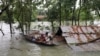 Warga menaiki perahu untuk pergi menuju tempat pengungsian di tengah banjir yang melanda kawasan timur laut Bangladesh di Kota Sylhet, pada 19 Juni 2022. (Foto: Reuters/Kazi Salahuddin Razu)