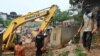 Les sauveteurs utilisent de la machinerie lourde pour rechercher des survivants après l'effondrement de maisons, le 16 juin 2022 à Abidjan.