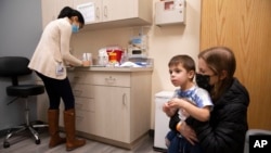 Ilana Diener bersama putranya, Hudson (3 tahun), menunggu untuk menerima suntikan vaksin COVID-19 produksi Moderna di kota Commack, New York (foto: dok).