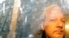 FILE: Buildings are reflected in the window as WikiLeaks founder Julian Assange is taken from court, where he appeared on charges of jumping British bail seven years ago, in London, May 1, 2019.