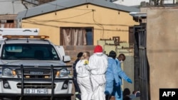 Members of the South African Police Service (SAPS) and forensic pathology service inspect the scene of a mass shooting in Soweto, South Africa, July 10, 2022. 