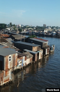 Shanty-town on the Saigon River; with downtown Saigon in the background. Urban planning aims to minimize slums caused by rural migration.(World Bank)
