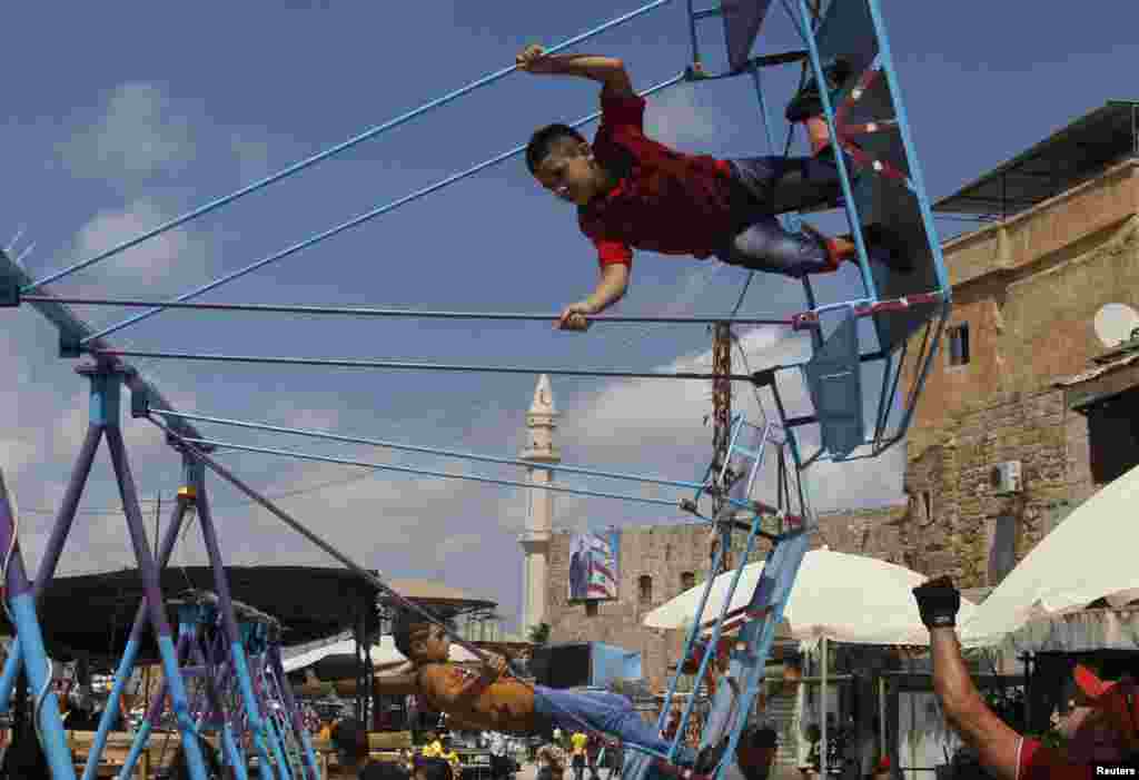 Anak-anak bermain ayunan di kota pelabuhan Sidon, Lebanon sebelah selatan, pada hari raya Idul Fitri, 8 Agustus 2013.