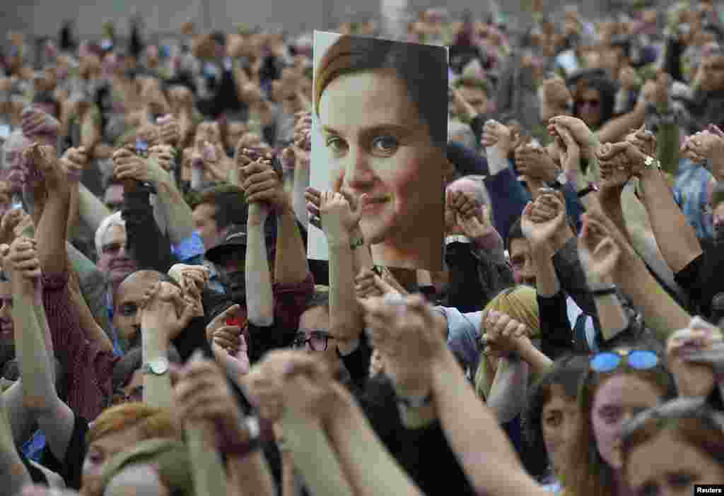 People hold hands as they attend a special service for murdered Labour Party MP Jo Cox, at Trafalgar Square in London, Britain.