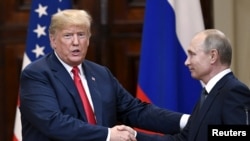 Le président américain Donald Trump et le président russe Vladimir Poutine se serrent la main après leur conférence de presse conjointe au palais présidentiel d'Helsinki, Finlande, 16 juillet 2018. 