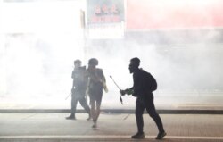 Anti-government protesters react as police fire tear gas during a demonstration, in Hong Kong, Nov. 2, 2019.