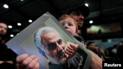 Seorang anak memegang potret foto Jenderal Garda Revolusi Iran, Qassem Soleimani di Beirut, Lebanon, 16 Februari 2020. (Foto: dok). Soleimani tewas dalam serangan pesawat nirawak Amerika Januari lalu.