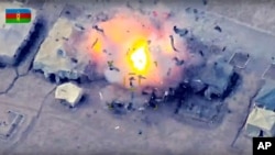 In this photo taken from video released by the Azerbaijan's Defense Ministry Oct. 2, 2020, Azerbaijan's forces attack an Armenian army camp during fighting in the disputed Nagorno-Karabakh region in Azerbaijan.