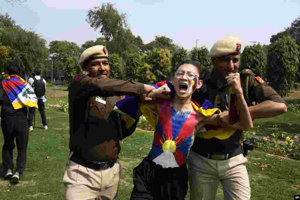 Polisi menahan seorang warga Tibet di pengasingan saat berunjuk rasa di luar kedutaan besar China untuk memperingati pemberontakan tahun 1959 di Tibet terhadap kekuasaan China, di New Delhi, India. (AP)