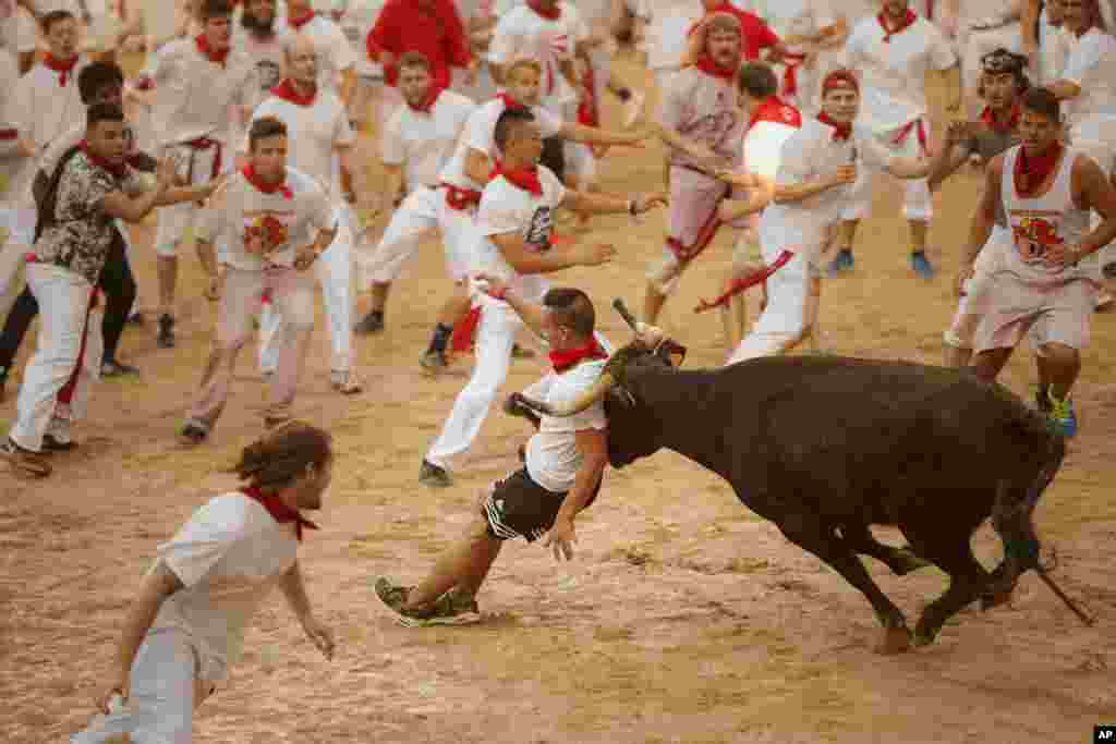 A reveler is charged by a bull during the running of the bulls at the 2016 San Fermin fiestas in Pamplona, Spain.