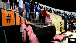 Des Sénégalais se tiennent devant le mur tombé au stade Demba Diop, le 15 juillet 2017, à Dakar.
