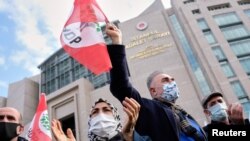 FILE - Supporters of Selahattin Demirtas, a jailed former co-leader of the pro-Kurdish Peoples' Democratic Party (HDP), wave party flags as they gather outside the Istanbul Justice Palace, the Caglayan Courthouse, in Istanbul, Turkey, Feb. 3, 2021.