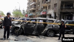 Un périmètre de sécurité est installé autour du véhicule du procureur général d'Egypte tué dans un attentat, le 29 juin 2015 au Caire. 