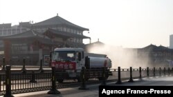 Sebuah truk menyemprotkan disinfektan di jalan di Xi'an di Provinsi Shaanxi utara China, 31 Desember 2021, di tengah lockdown karena COVID-19. (Foto: AFP)