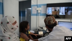 FILE - A Pakistani paramedic checks a child at a telemedicine center run by the government of Khyber Pakhtukhwa in the remote Behali area, Oct. 20, 2017. Singapore has introduced telemedicine legislation as part of its Healthcare Services Act 2020.