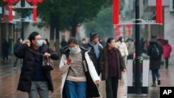 Watu mitaani wamejifunika uso kujikinga na kirusi corona katikati ya mji wa Wuhan, China, Jumatano, Jan. 22, 2020. 