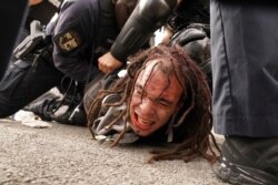 Louisville police detain a man after a group marched, Sept. 23, 2020, in Louisville, Ky. A grand jury has indicted one officer on criminal charges six months after Breonna Taylor was fatally shot by police in Kentucky.