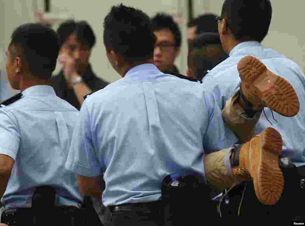A protester is carried away by police officers after staying overnight in Hong Kong's financial district, July 2, 2014.