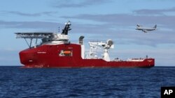 In this April 9, 2014 photo provided by the Australian Defense Force, a Royal Australian Air Force AP-3C Orion flies past Australian Defense vessel Ocean Shield on a mission to drop sonar buoys to assist in the acoustic search of the missing Malaysia Airlines plane. 