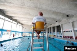 A lifeguard watches over swimmers at the Marville indoor swimming pool which is part of the Marville sports complex, in Saint-Denis, France, July 21, 2017.