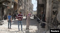 Warga setempat memeriksa kerusakan pasca serangan udara di wilayah al-Maysar, Aleppo, Suriah (11/4). 