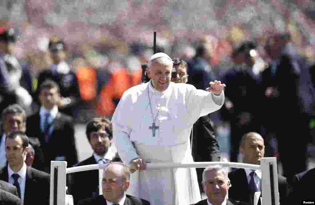 Pope Francis waves as he leads the Easter mass in Saint Peter's Square at the Vatican, April 20, 2014. 