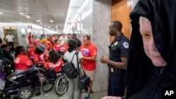 David Barrows of Washington, right, dresses as the grim reaper and wears a sign that reads "Give me your poor, your sick, and your uninsured" as he joins others on Capitol Hill, Sept. 25, 2017.