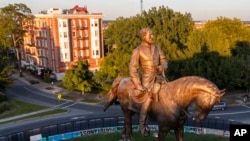 The statue of Confederate Gen. Robert E. Lee is bathed in the late sun on Monument Avenue in Richmond, Va., Sept. 6, 2021. 