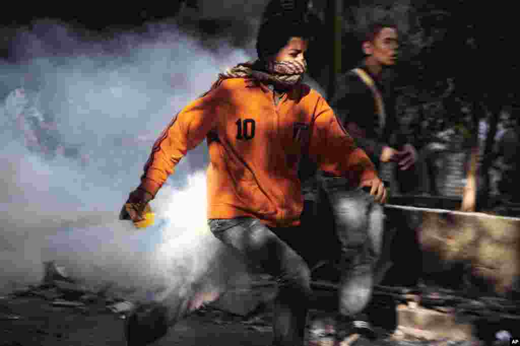 An Egyptian protester runs during clashes with security forces near Tahrir Square in Cairo, Egypt, November 25, 2012. 