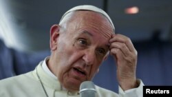 FILE - Pope Francis gestures during a news conference on board the plane during his flight back from a trip to Chile and Peru, Jan. 22, 2018. 